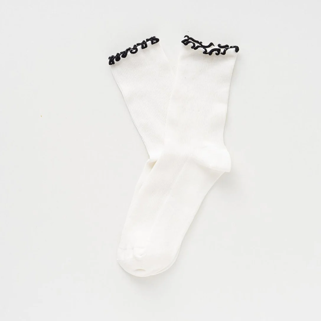 Schwarze Rüschensocken von KLUE aus Bio-Baumwolle mit feinem gewelltem Rüschenabschluss am Knöchel.