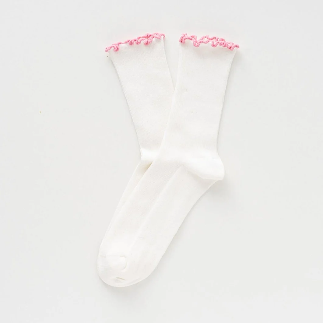 Pinke Rüschensocken von KLUE aus Bio-Baumwolle mit dekorativem gewelltem Rüschenabschluss am Knöchel.