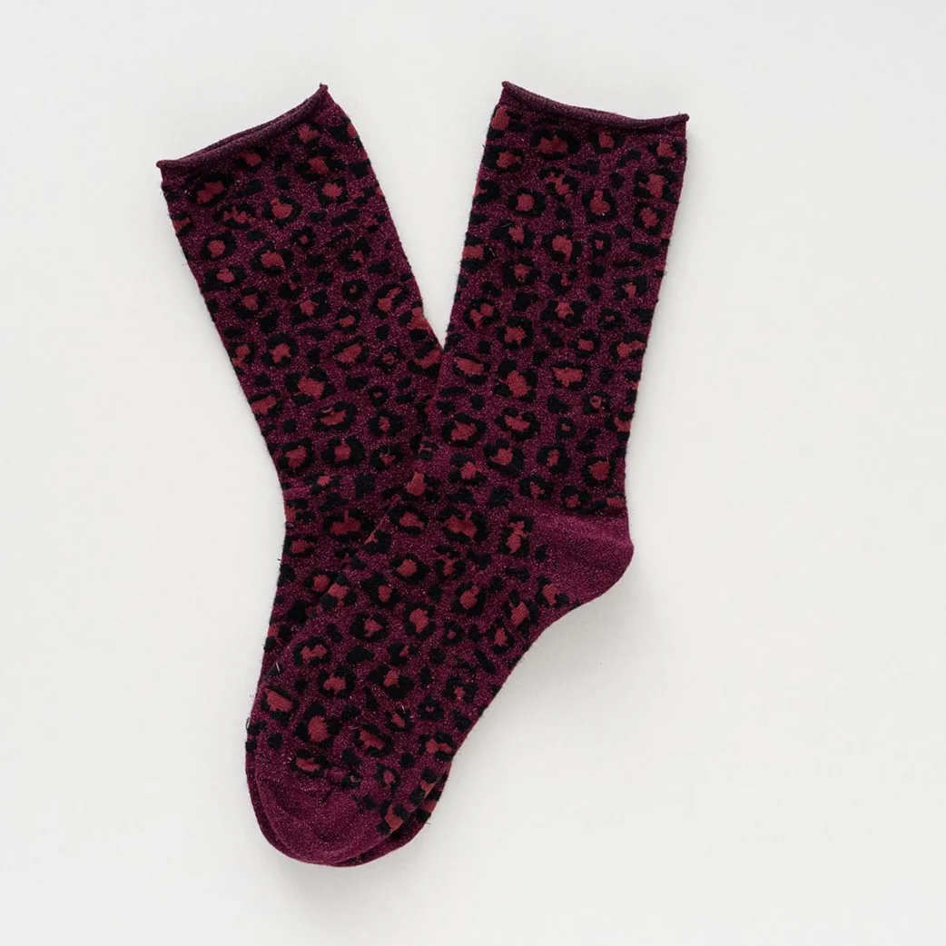 Burgunderrote KLUE Leo Glitzersocken aus Lyocell mit Leopardenmuster, Metallic-Schimmer und umgeschlagenem Bündchen.