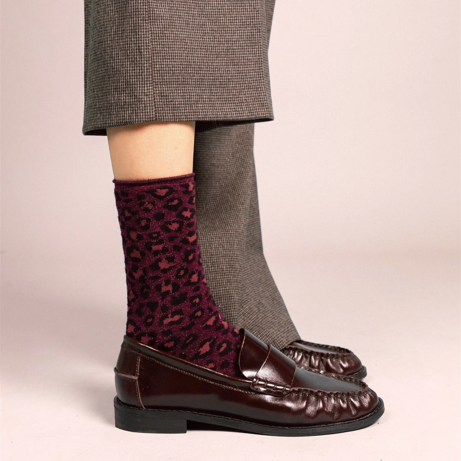 Burgunderrote KLUE Leo Glitzersocken aus Lyocell mit Leopardenmuster, Metallic-Schimmer und umgeschlagenem Bündchen.