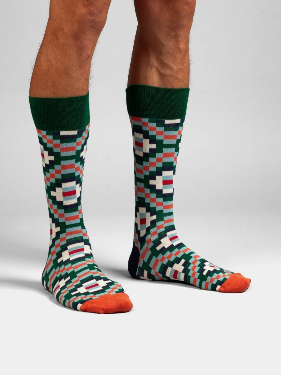 Dunkelgrüne Tribal Tiles Rautensocken von DillySocks aus Bio-Baumwolle mit geometrischem Muster in Hellblau, Orange und Grün.