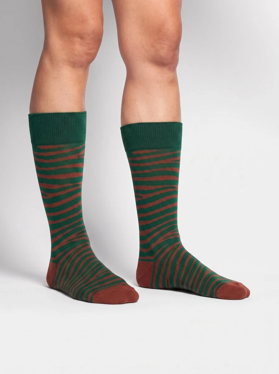 Dunkelgrüne Wild Stripes Zebrasocken von DillySocks aus Bio-Baumwolle mit wellenförmigem Zebramuster in Grün und Braun.