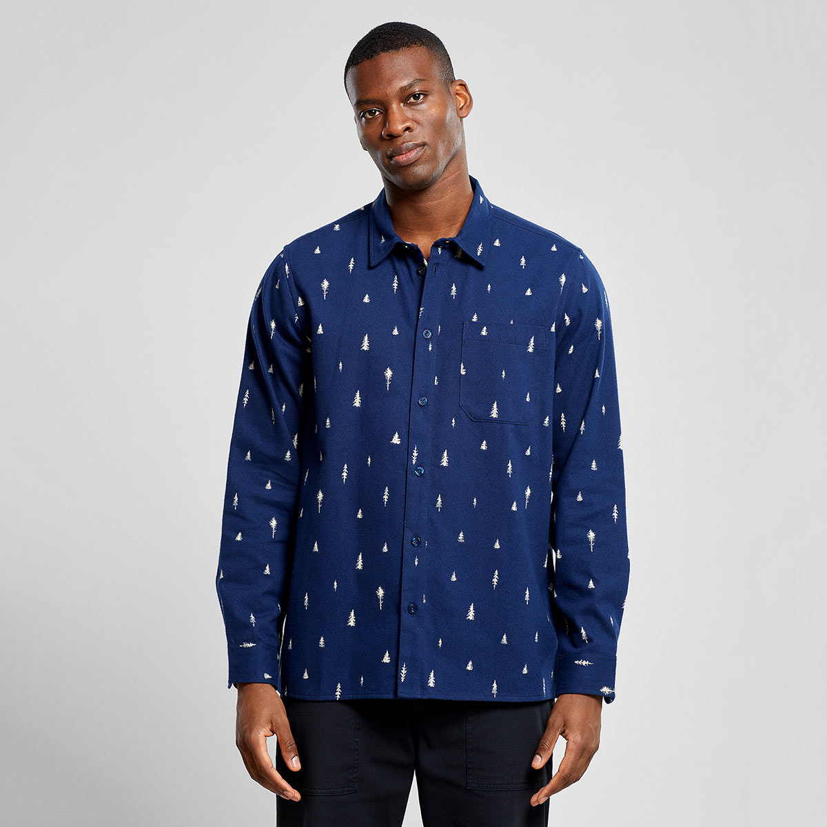 Lässiges dunkelblaues Hemd aus kuscheligem Bio-Baumwollflanell von Dedicated, umweltfreundlich bedruckt mit weißen Nadelbaumsilhouetten.