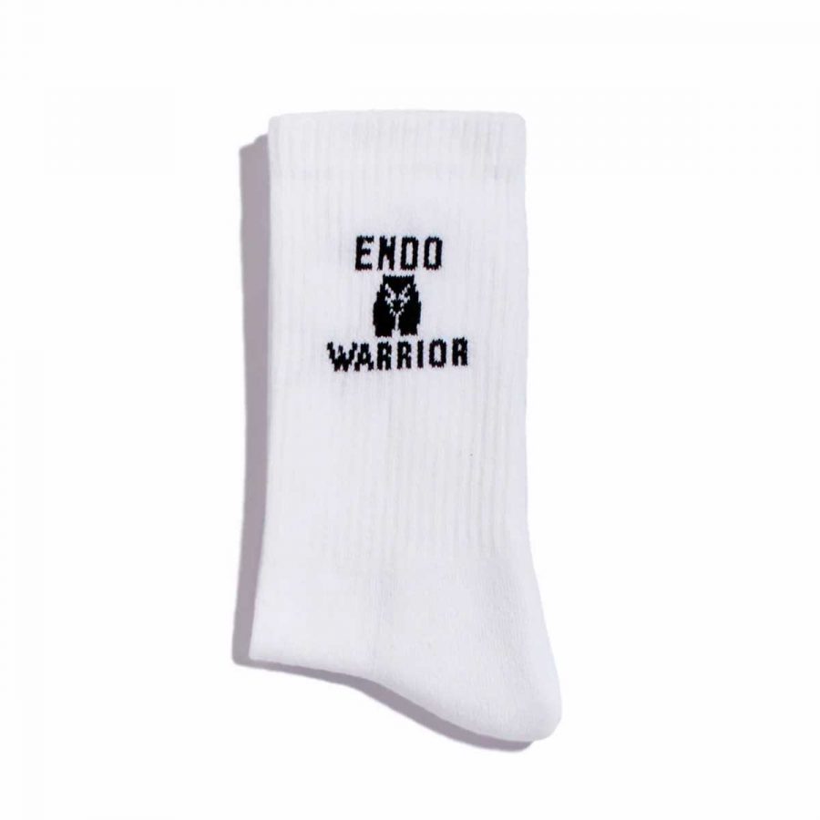 Weiße Tennissocken von La Dolce Vulva mit EndoWarrior Aufschrift, die auf die Schwierigkeiten von Personen mit Endometriose aufmerksam machen sollen.